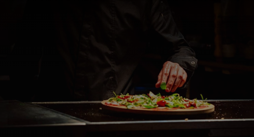 Dernière touche de préparation sur une planche de charcuterie italienne artisanale