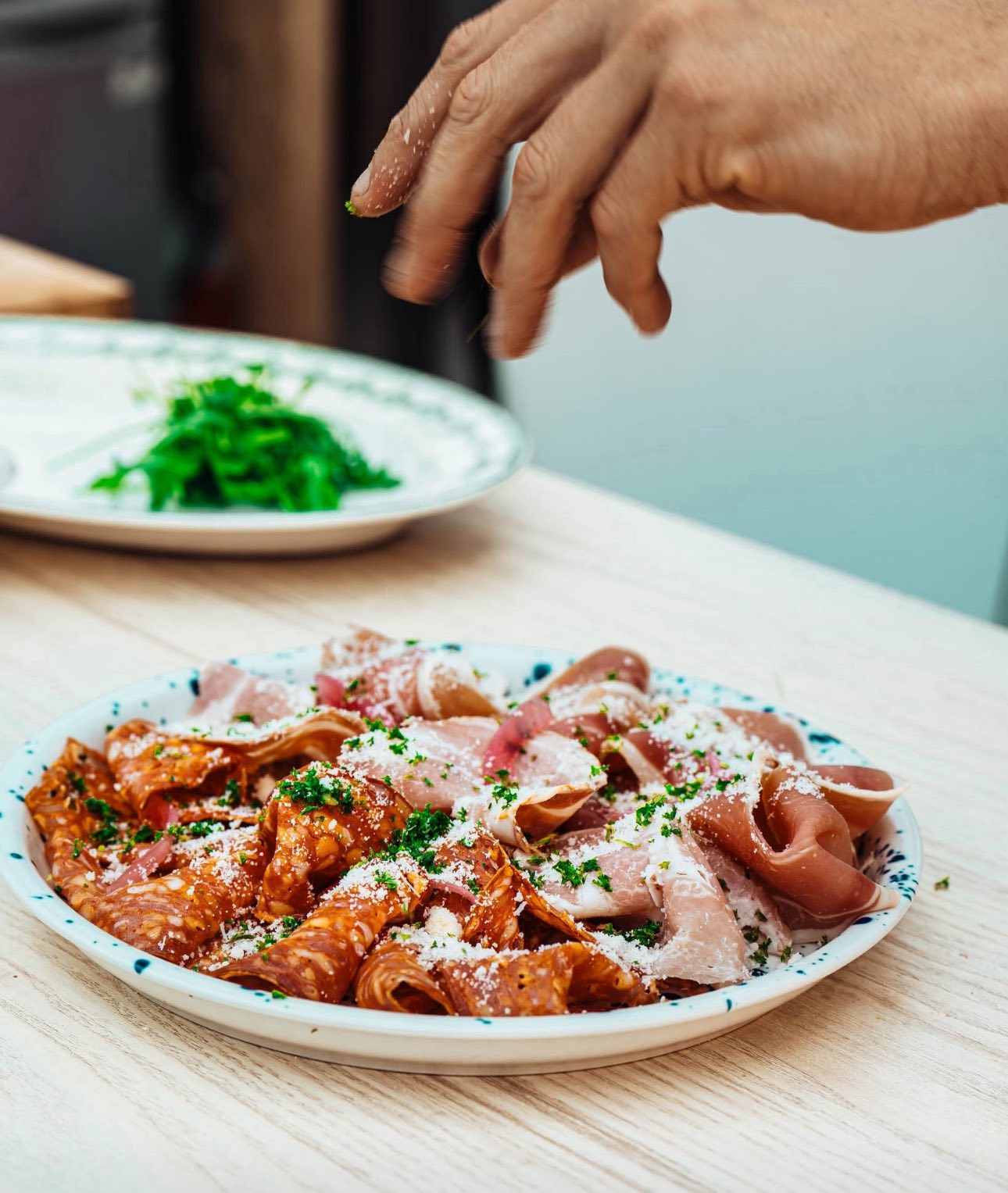 Assiette de charcuterie italienne saupoudrée de parmesan frais